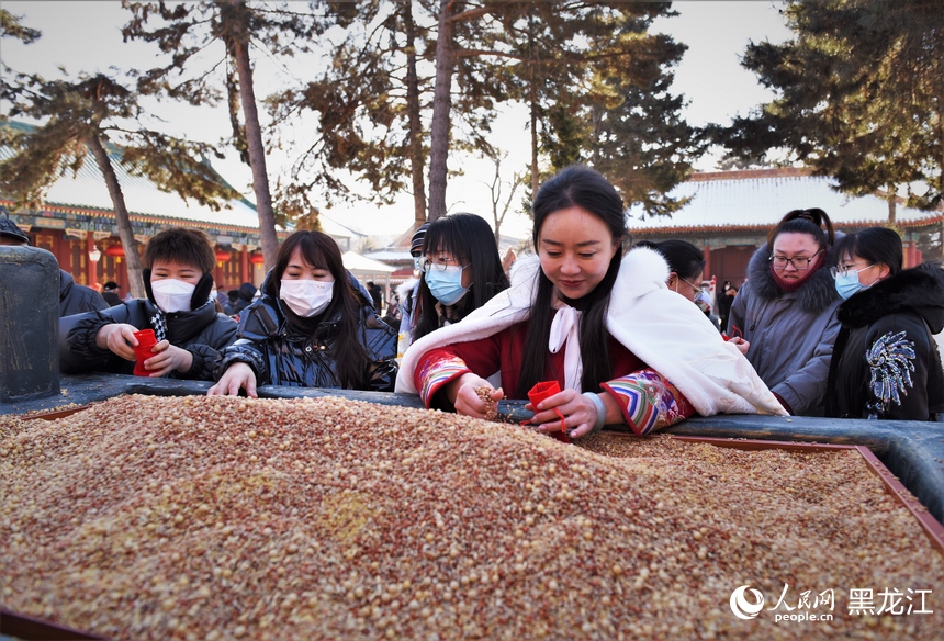 市民將五谷裝入福袋，寓意五谷豐登好收成。人民網(wǎng) 蘇靖剛攝