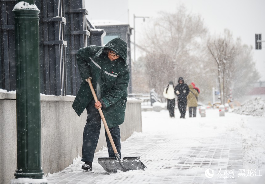 哈爾濱地鐵工作人員正在清理地鐵站周邊積雪。人民網(wǎng)記者 蘇靖剛攝